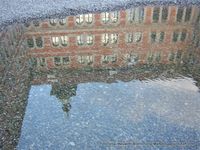Das Grazer Jesuitenkollegium spiegelt sich in einer  Wasserlacke. Graz 1. Bezirk - Innere Stadt